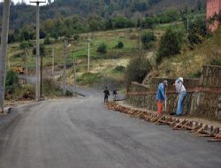 ASFALTLANAN YOLLA KALDIRIM YAPILIYOR